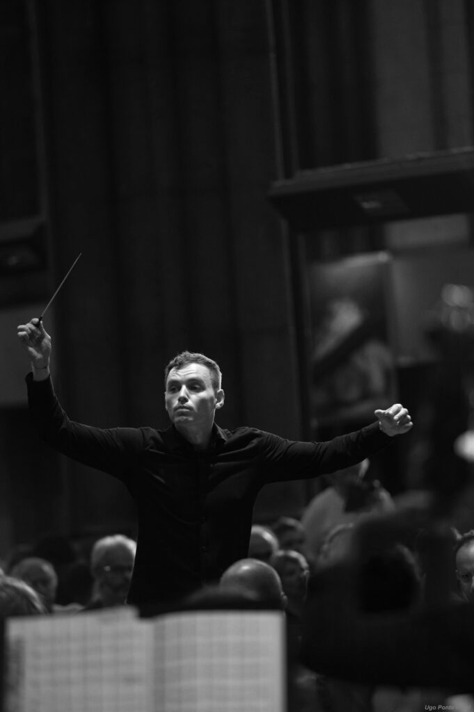 Paweł Kapuła à la direction du Te Deum Paweł Kapuła dirigeant le Te Deum, baguette levée, photographie en noir et blanc
