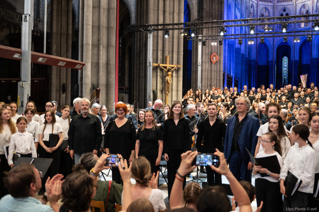 Les saluts finals du Te Deum devant le public Les artistes saluant le public à la fin du Te Deum, devant les choristes réunis